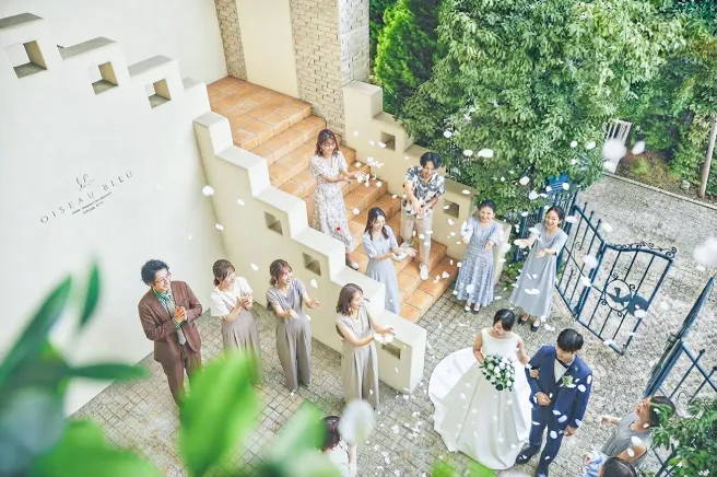 ガーデンの階段でゲストに祝福される新郎新婦